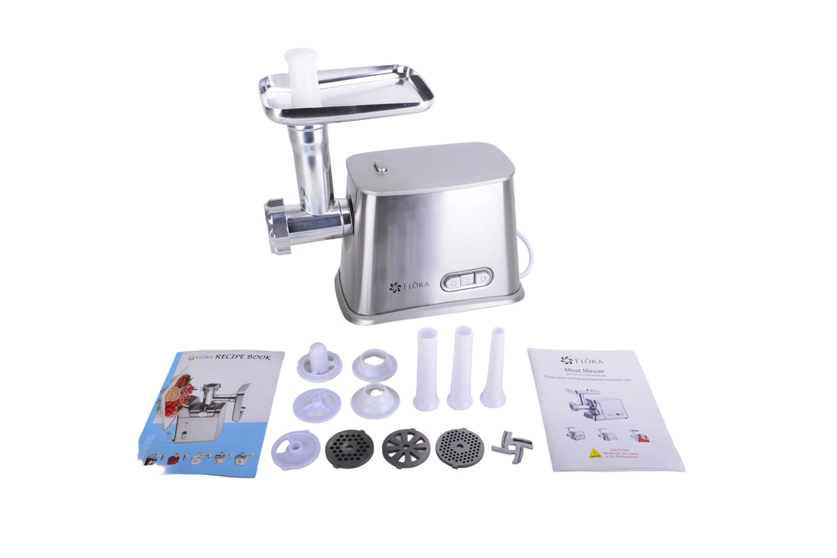 A stainless steel electric meat grinder with its accessories and manuals laid out on a white surface against a white background.