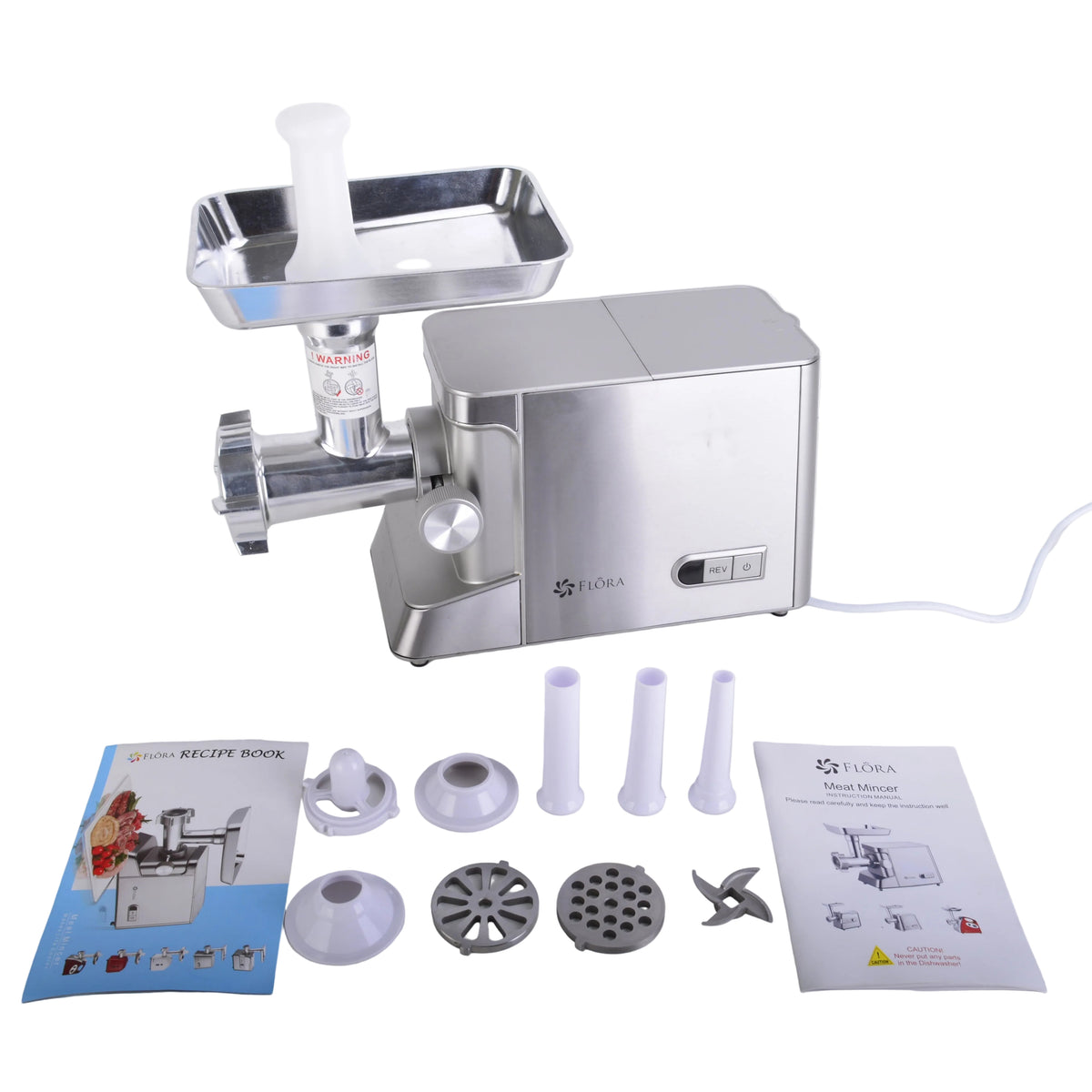 A stainless steel electric meat grinder with its accessories and manuals laid out on a white surface against a white background. The grinder has a silver body and a metal hopper on top, with various attachments, a power cord, and printed recipe book and instruction sheets in front.