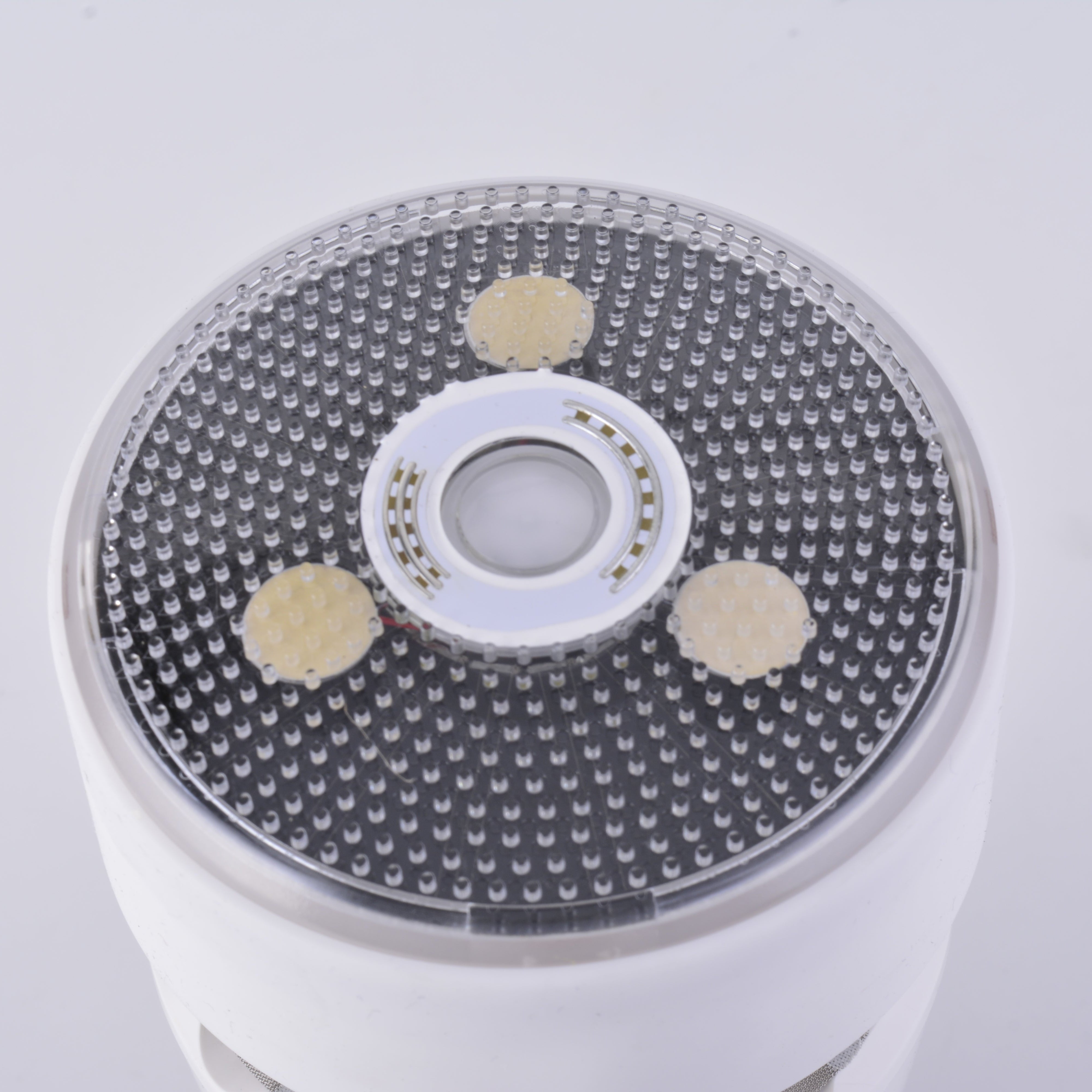 Close-up of a white electronic device with a textured surface on a light gray background